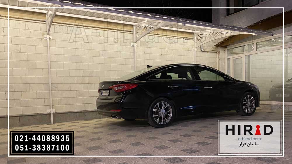 سایبان ماشین نصب شده روی دیوار بدون پایه مزاحم رنگ سایبان سفید و یک ماشین مشکی زیر سایبان پارک شده